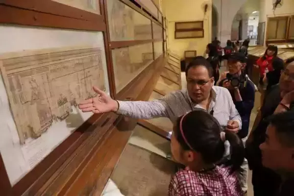在埃及博物馆，导游给中国游客介绍纸莎草纸上的历史记录。